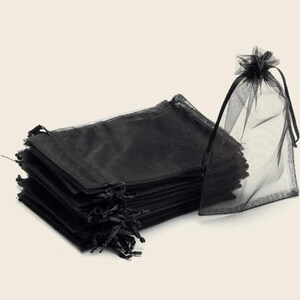 Peut inclure: Un lot de sacs cadeaux en organza noir transparent, avec un sac debout. Les sacs sont faits d'un tissu d&eacute;licat et transparent et ont une fermeture &agrave; cordon.