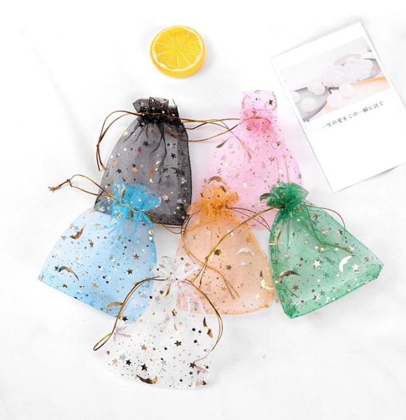 Peut inclure: Six petits sacs cadeaux en tulle en forme d'&eacute;toile avec des accents de paillettes dor&eacute;es. Les sacs sont de diff&eacute;rentes couleurs&nbsp;: noir, rose, bleu clair, blanc, vert et orange.