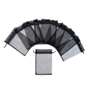 Peut inclure: Dix sacs cadeaux en organza noir transparent avec cordon de serrage. Les sacs sont dispos&eacute;s en demi-cercle avec un sac au centre.