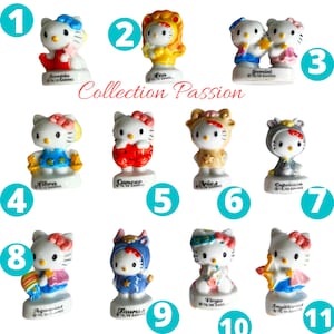 May include: A collection of eleven Hello Kitty figurines, each representing a different zodiac sign. The figurines are white with colourful outfits and accessories, and each has the zodiac sign's name on the base.