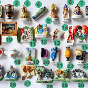 May include: A collection of miniature ceramic figurines, including Egyptian figures, paintings, and decorative objects. The figurines are brightly colored and detailed, showcasing various themes and designs. The collection includes a teapot, a vase, and a statue of liberty.