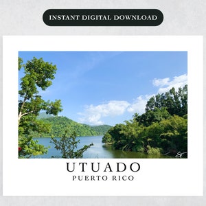 May include: A scenic view of a lake surrounded by lush green trees and mountains under a bright blue sky with white clouds. The text "UTUADO PUERTO RICO" is at the bottom of the image.