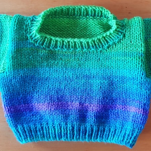 May include: A knitted sweater with a green, blue, and purple ombre pattern. The sweater has a round neckline and short sleeves.