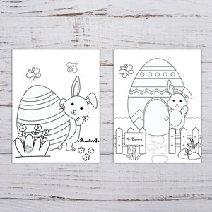 Pode incluir: Duas p&aacute;ginas para colorir em preto e branco com coelhos da P&aacute;scoa. A primeira p&aacute;gina mostra um coelho em p&eacute; ao lado de um ovo grande com listras. A segunda p&aacute;gina mostra um coelho em p&eacute; em frente a uma casa em forma de ovo com uma placa que diz "Mr. Bunny".