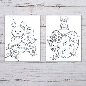 Pode incluir: Duas p&aacute;ginas para colorir em preto e branco com coelhos e ovos de P&aacute;scoa. A primeira p&aacute;gina mostra um coelho segurando um cartaz que diz "Ovos gr&aacute;tis!" e um pintinho. A segunda p&aacute;gina mostra dois coelhos com uma pilha de ovos de P&aacute;scoa.