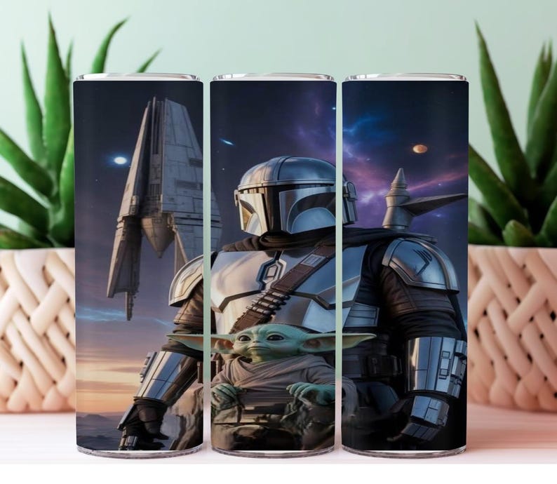 K&ouml;nnte beinhalten: Ein Edelstahlbecher mit einer detaillierten Illustration von The Mandalorian und Grogu, vor einer Weltraumszene mit einem Raumschiff. Das Design umfasst eine Figur mit Helm und einen kleinen gr&uuml;nen Au&szlig;erirdischen. Der Becher ist zylindrisch.