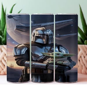 May include: A stainless steel tumbler featuring a detailed illustration of The Mandalorian holding Grogu, with a spaceship and a planet in the background. The artwork is set against a dark, space-themed backdrop, with a sunset-colored horizon.