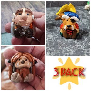 May include: A 3-pack of handmade polymer clay figurines. The figurines are of a goblin, a dog wearing a pirate hat, and a furry creature with large teeth. The figurines are all about 2 inches tall.