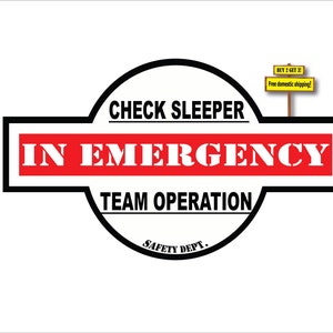 May include: Black and white sign with red text that reads "CHECK SLEEPER IN EMERGENCY TEAM OPERATION SAFETY DEPT.". A small yellow sign above reads "BUY 2 GET 2 Free domestic shipping!"