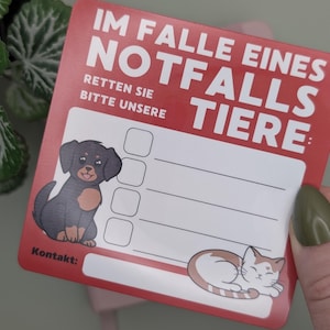 May include: A red and white pet emergency contact card with the German text "IM FALLE EINES NOTFALLS TIERE" and "RETTEN SIE BITTE UNSERE". Features a cartoon dog and cat, with space for contact information.