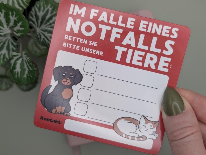 May include: A red and white pet emergency contact card with the German text "IM FALLE EINES NOTFALLS TIERE" and "RETTEN SIE BITTE UNSERE". Features a cartoon dog and cat, with space for contact information.