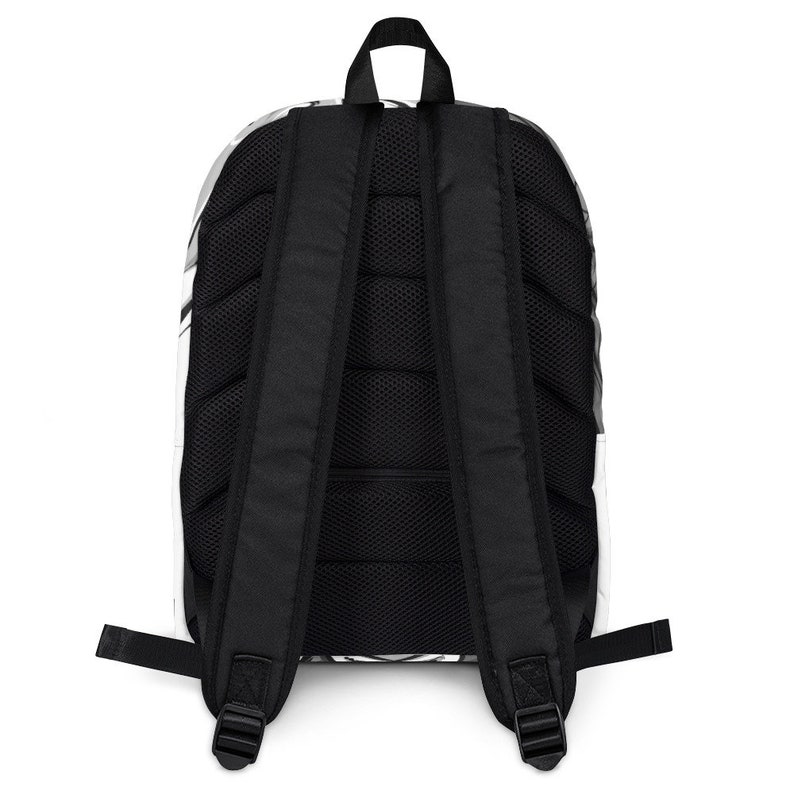 May include: Black backpack with a white and grey pattern. The backpack has a mesh back panel and adjustable straps.