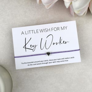 May include: A white card with the text "A LITTLE WISH FOR MY Key Worker" and a purple string bracelet with a small heart charm. The card includes instructions to tie the bracelet and make a wish.