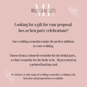 May include: A pink background with white text that reads "MOLLY LANE GIFTS" and "Looking for a gift for your proposal box or hen party celebrations? Our wedding scrunchies make the perfect addition to your wedding. Choose from a coloured scrunchie for the bridal party, a white scrunchie for the bride to be. All presented on a printed backing card. We do have a wide range of wedding scrunchies, wedding wish bracelets and proposal boxes available."