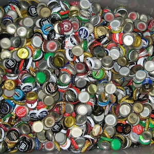 May include: A large collection of colorful bottle caps, many with logos and designs. The caps are mostly silver, gold, and red, with some green and blue accents. Some caps have the number 88 on them.