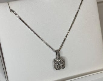 May include: A silver chain necklace with a square pendant set with small diamonds.