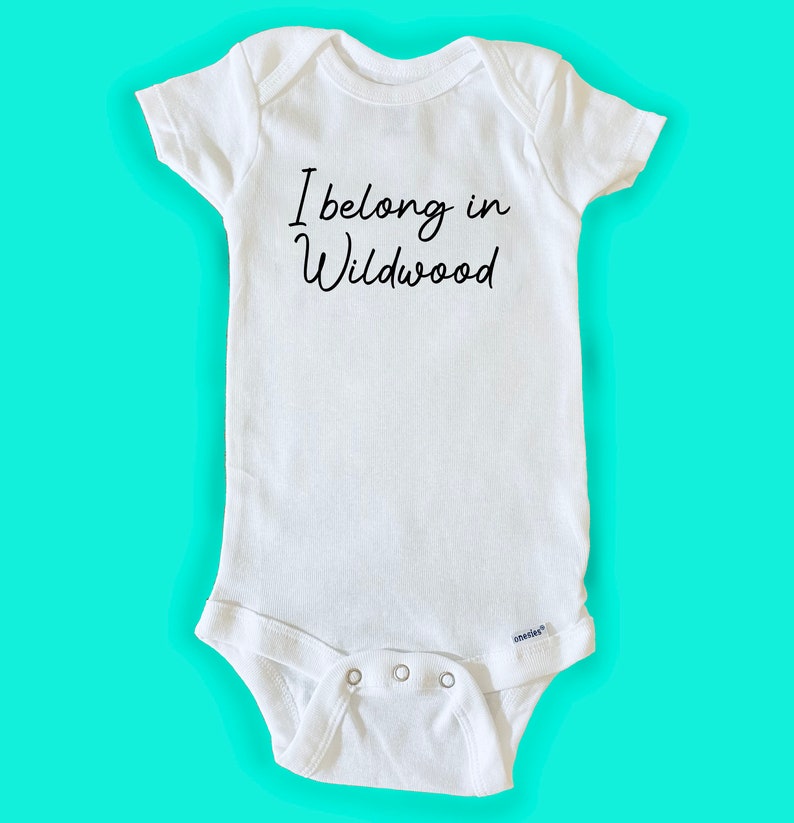 May include: White baby onesie with black text that reads "I belong in Wildwood".