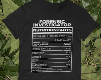 May include: Black t-shirt with a white graphic of a nutrition facts label for a "Forensic Investigator". The label lists the percentage daily value for dedication, strong stomach, innovation, caffeine, sleep, and hardworking.