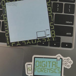 May include: A light blue sticky note with a black border and digital-style green accents, featuring a laptop, phone, and tablet icon. Below, a sticker with the text "DIGITAL FORENSICS" on a computer screen, and a phone icon.