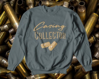 May include: A dark blue sweatshirt with the text "Casing Collector" in a gold script font. Two gold bullet casings are shown below the text.