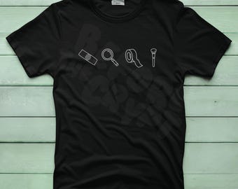 May include: Black t-shirt with white line art of a magnifying glass, tape, a makeup brush, and a film strip. The words "Best Day Ever" are faintly visible in the background.