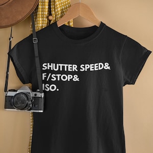 Könnte beinhalten: Schwarzes T-Shirt mit weißem Text, der "Shutter Speed & F/Stop & ISO." lautet.