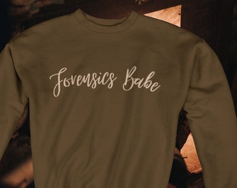 May include: A brown sweatshirt with the text "Jovensics Babe" in white cursive lettering.