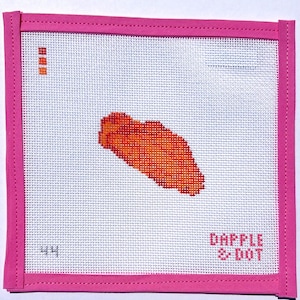 May include: A square needlepoint canvas featuring a central orange and red chicken wing design. The canvas has a bright pink fabric border, the number 44 in the bottom left corner, and the text DAPPLE & DOT in the bottom right corner.