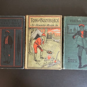 May include: Three vintage books with illustrations and titles: "Julius the Street Boy," "Tom the Bootblack," and "Young Outlaw." The covers feature illustrations of young boys and text by Horatio Alger Jr. The books are in various colors, including black, green, and gold.