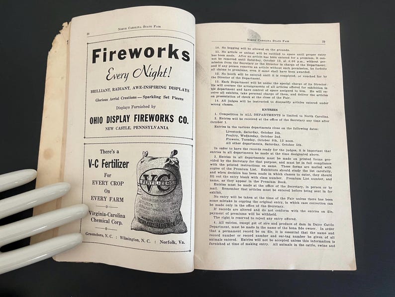 May include: Open book with text and illustrations. The left page features a fireworks advertisement with the text "Fireworks Every Night!" and the Ohio Display Fireworks Co. The right page contains text about the North Carolina State Fair.