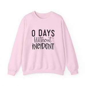 May include: Pink sweatshirt with black text that reads "0 Days Without Incident".