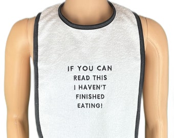 May include: White bib with black trim and the text "If you can read this I haven't finished eating!"