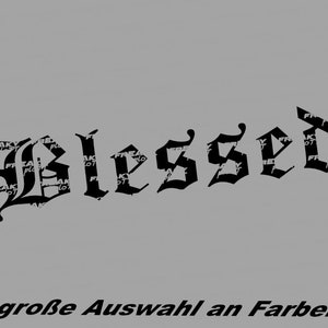 Peut inclure: Texte noir de style gothique qui dit "Blessed" sur un fond gris. En dessous du mot "Blessed" se trouve le texte "große Auswahl an Farben". Le mot "Freaky Plot" est imprimé en blanc sur les lettres.