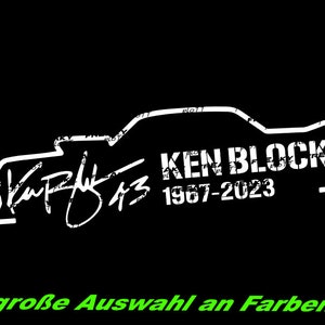 Könnte beinhalten: Eine weiße Silhouette eines Autos mit dem Text "Ken Block 1967-2023" und einer Unterschrift darunter. Der Text "große Auswahl an Farben" befindet sich am unteren Rand des Bildes.