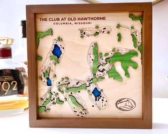 May include: A wooden framed map of The Club at Old Hawthorne golf course in Columbia, Missouri. The map is laser cut and features a green and blue color scheme. The course is outlined in brown and the holes are numbered. The bottom right corner of the map features a horse logo.