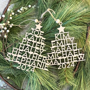 Puede incluir: Dos adornos de árbol de Navidad de madera con nombres y el año 2024. Los adornos tienen la forma de un árbol de Navidad con los nombres de los miembros de la familia escritos en cada nivel del árbol.