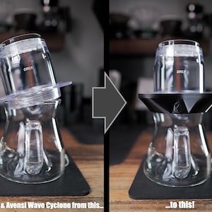Könnte beinhalten: Ein transparenter Kaffeefilter aus Glas mit OREA-Aufschrift auf einer Glaskaraffe, dargestellt in zwei Konfigurationen: eine mit transparentem Kunststoffboden und eine mit schwarzem, facettiertem, geometrischem Adapterboden. Der Text lautet: Take your Z1 & Avensi Wave Cyclone from this... to this!