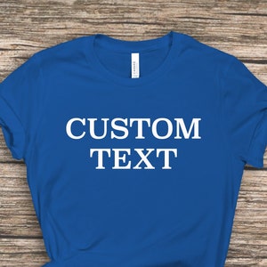 May include: A royal blue t-shirt with the text "CUSTOM TEXT" printed in white on the front.