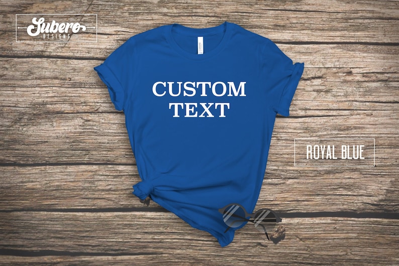 May include: A royal blue t-shirt with the text "CUSTOM TEXT" printed in white on the front.