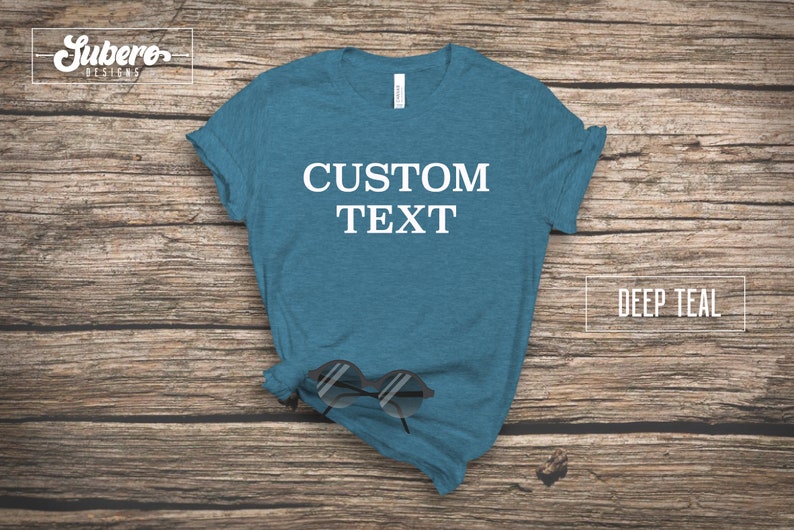 May include: A deep teal t-shirt with the text "CUSTOM TEXT" printed in white on the front.