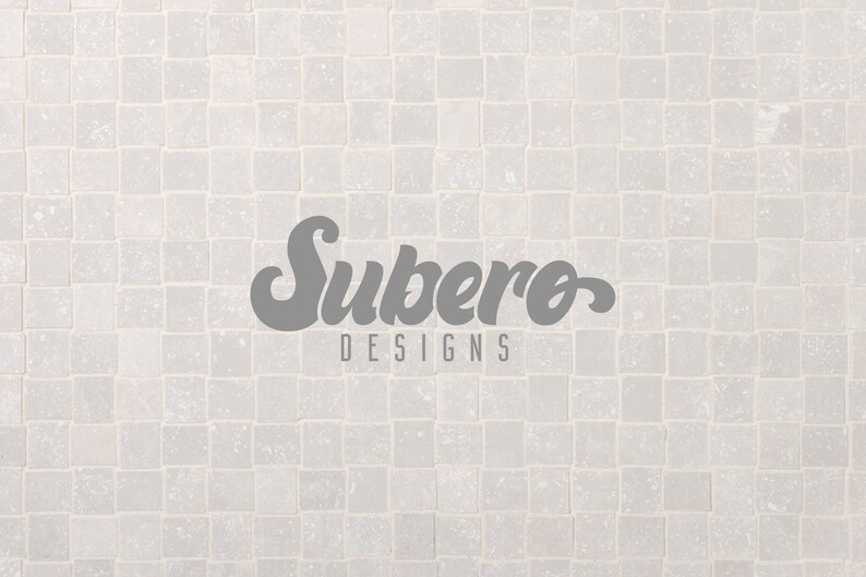 K&ouml;nnte beinhalten: Ein wei&szlig;er Fliesenhintergrund mit dem Text "Subero Designs" in grauer Schrift.