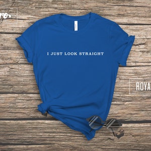 May include: Royal blue t-shirt with the text "I just look straight" printed in white on the front.
