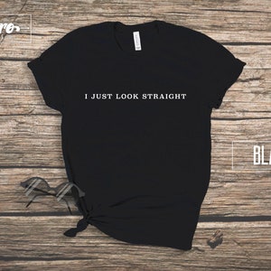 May include: Black t-shirt with the text "I JUST LOOK STRAIGHT" printed in white on the front.