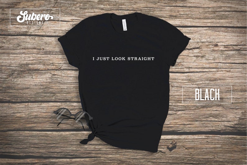 May include: Black t-shirt with the text "I JUST LOOK STRAIGHT" printed in white on the front.
