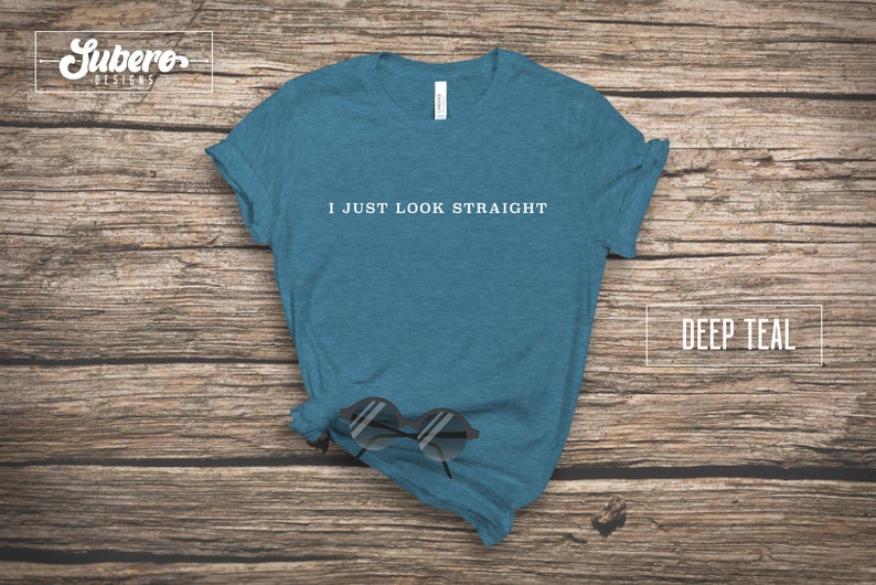 May include: A deep teal t-shirt with the text "I just look straight" printed in white on the front.