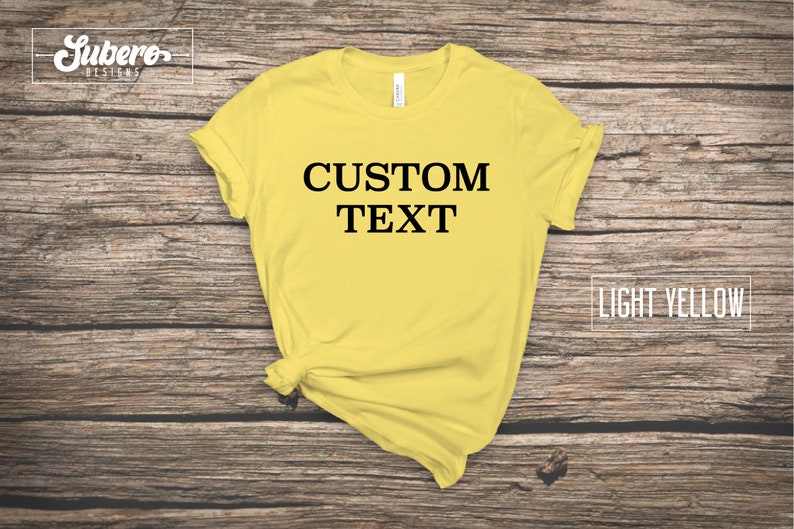 May include: A light yellow t-shirt with the text "CUSTOM TEXT" printed in black on the front.
