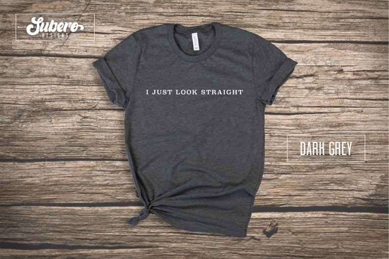 May include: Dark grey t-shirt with the text "I JUST LOOK STRAIGHT" printed in white on the front.