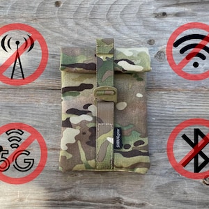 Può includere: Una custodia in tessuto mimetico con una cinghia e una fibbia nere. La custodia ha il testo "SHRUIGGEAR" stampato sulla cinghia. La custodia è circondata da cerchi rossi con simboli neri che rappresentano l'assenza di segnale, wifi, 5G e bluetooth.
