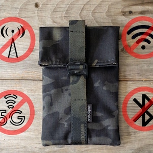 May include: A black and green camouflage fabric pouch with a black strap and a black buckle. The pouch has a label that says "SHRUGEAR". The pouch is surrounded by red circles with black symbols that indicate no cell service, no wifi, no 5G, and no bluetooth.