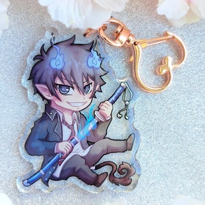 Peut inclure: Un porte-cl&eacute;s repr&eacute;sentant un personnage d'anime bleu et noir avec un motif de flamme bleue et une cha&icirc;ne dor&eacute;e. Le personnage tient une &eacute;p&eacute;e bleue avec une poign&eacute;e dor&eacute;e.